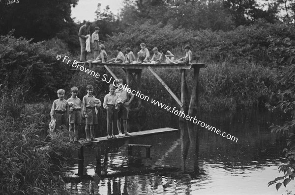 GROUP OF BOY ON DIVING BOARD BY RIVER